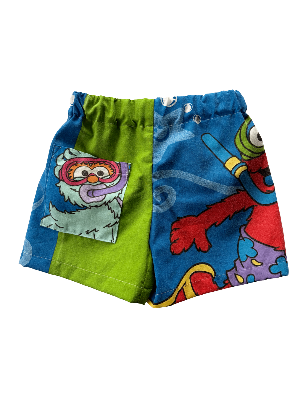 A pair of colourful children's shorts featuring cartoon graphics, including a blue side with elmo.
