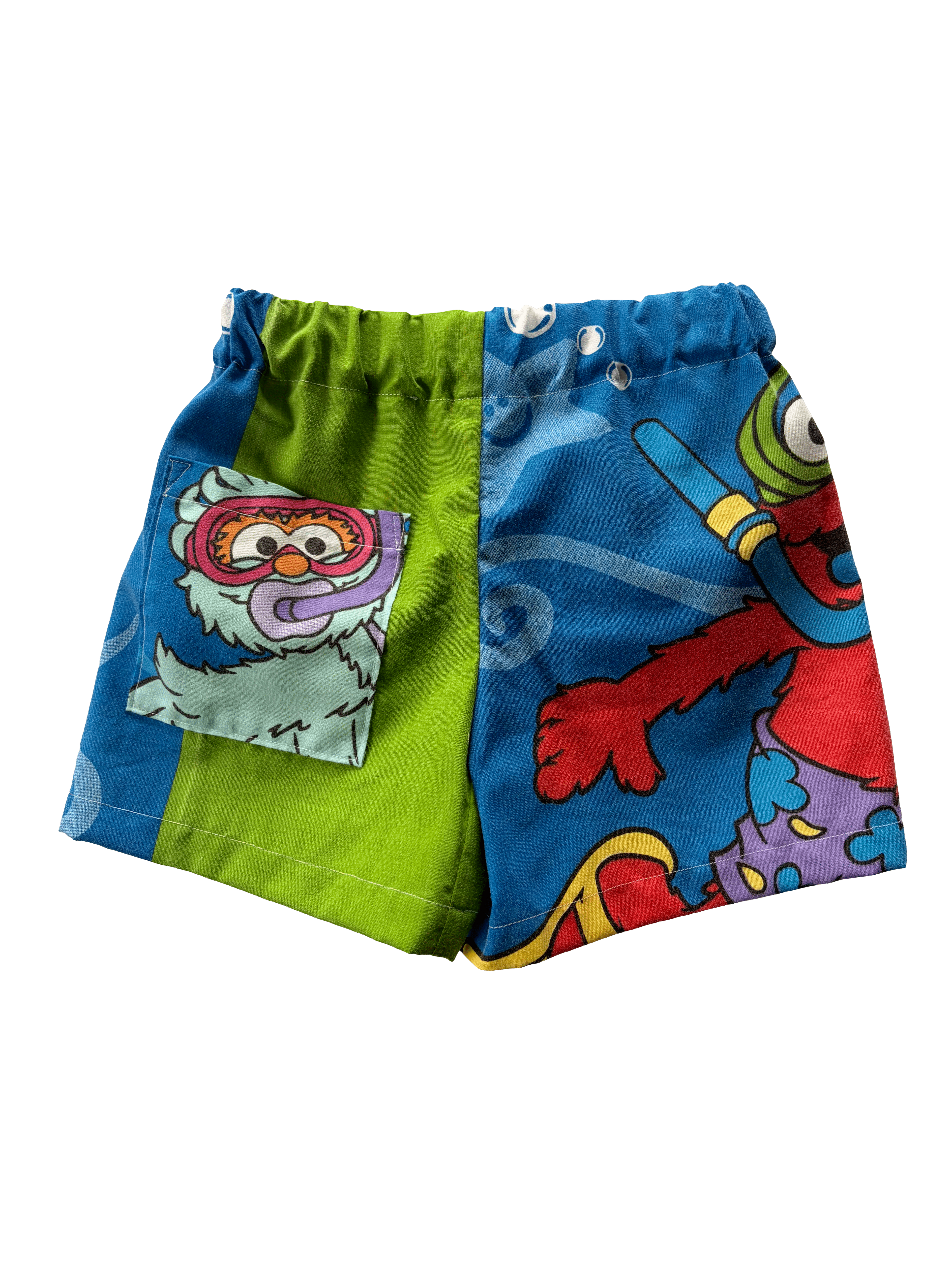 A pair of colourful children's shorts featuring cartoon graphics, including a blue side with elmo.