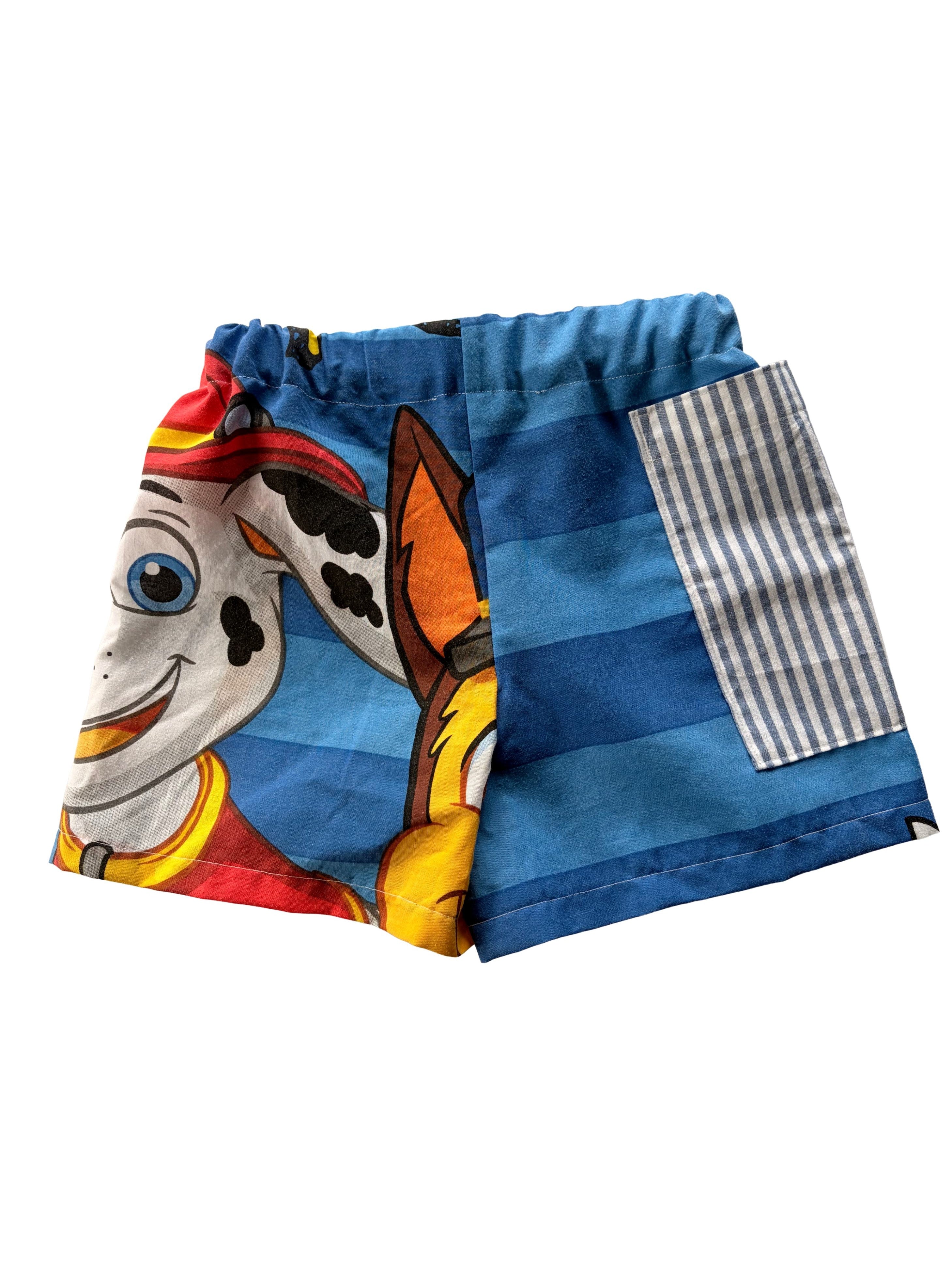 Handmade upcycled kids' shorts with blue stripes, featuring Marshall from Paw Patrol with a large striped pocket. Made from a secondhand duvet.
