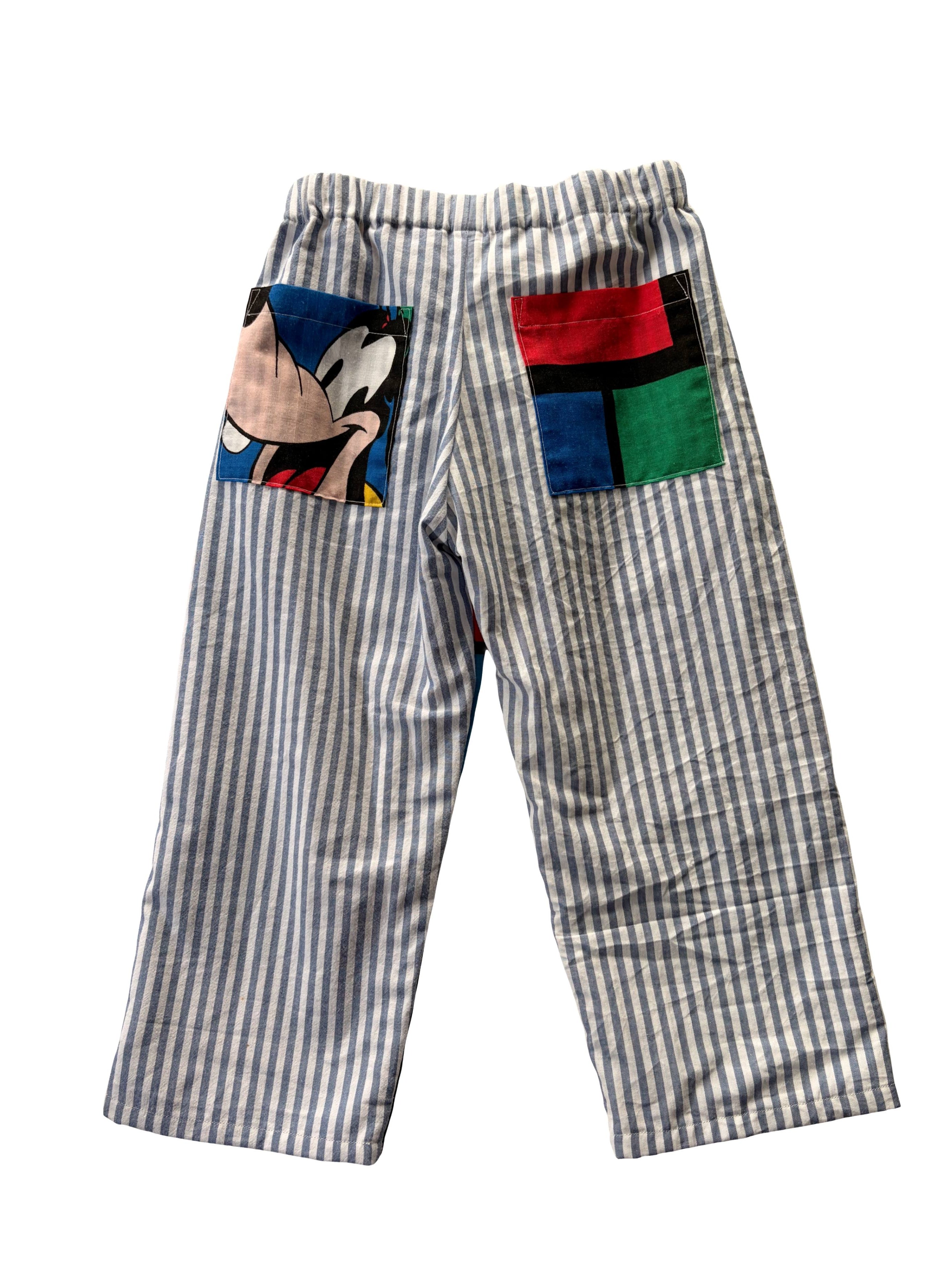 Children's pants, blue stripes with two pockets on back of pants. Goofy pocket and block pattern on other pocket.